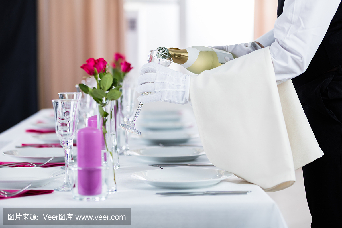 侍者往杯子里倒香檳